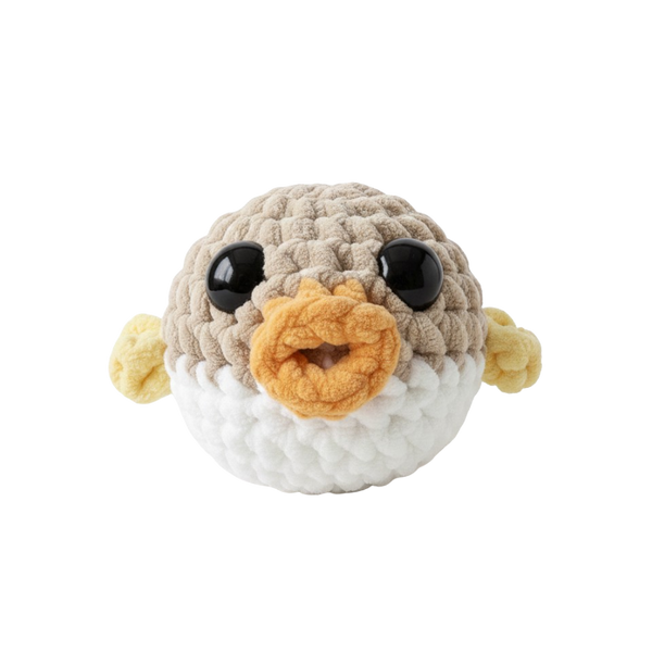 Crocheted pufferfish toy with a white background