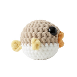 Crocheted toy resembling a pufferfish on a white background