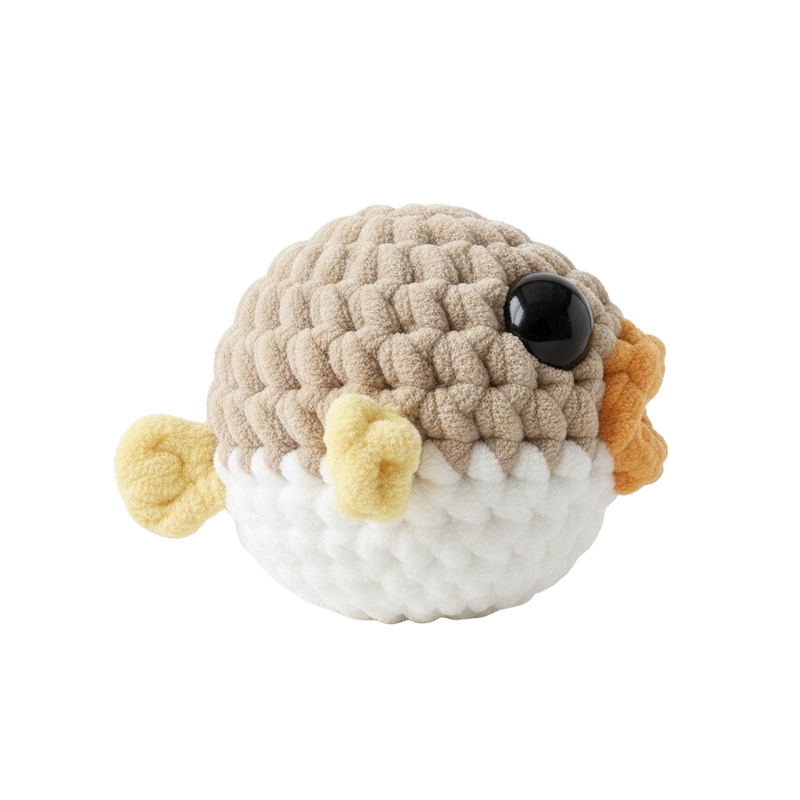 Crocheted toy resembling a pufferfish on a white background